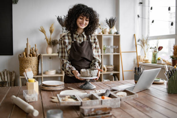 istock Young woman working in pottery studio with laptop 2155607565