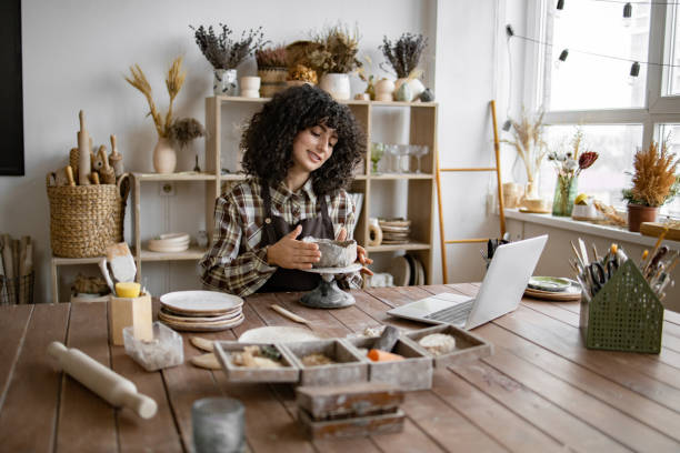 istock Woman crafting ceramics in home studio with laptop 2155607570