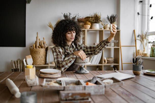 istock Female potter taking selfie in studio with ceramics tools 2155607585