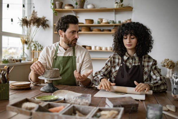 istock Mature bearded man and woman creating pottery in workshop 2155607594