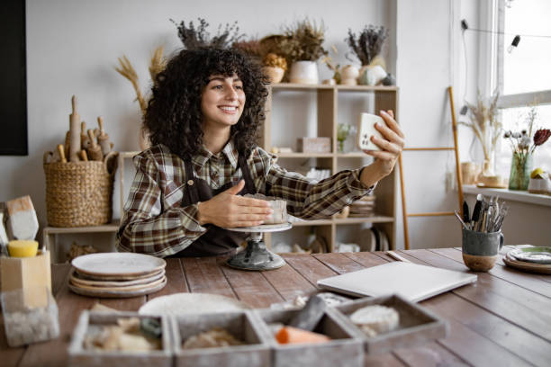 Woman potter recording online pottery class in studio