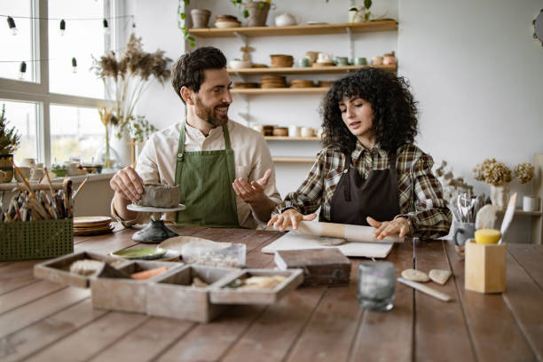 istock Mature man and woman sculpting clay in art studio 2155607605