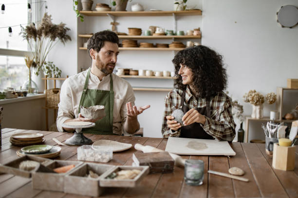 istock Mature man and woman sculpting clay pottery in studio 2155607622