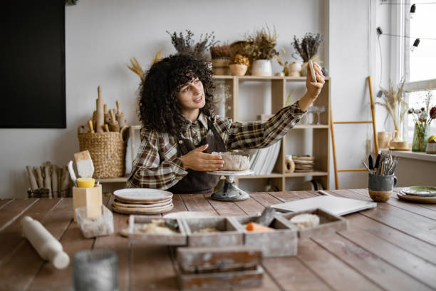 istock Female potter recording vlog in studio while sculpting clay 2155607628