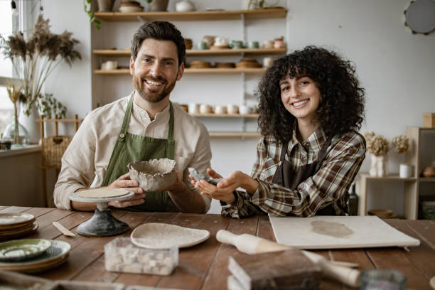 istock Bearded man and woman sculpting pottery in art studio 2155607631