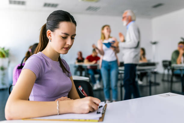 istock Focused young woman taking notes from books for her study. College student sitting at desk and studying 2155607915