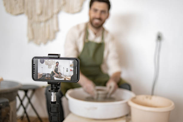 istock Male potter recording a vlog while sculpting on a potter's wheel 2155610095