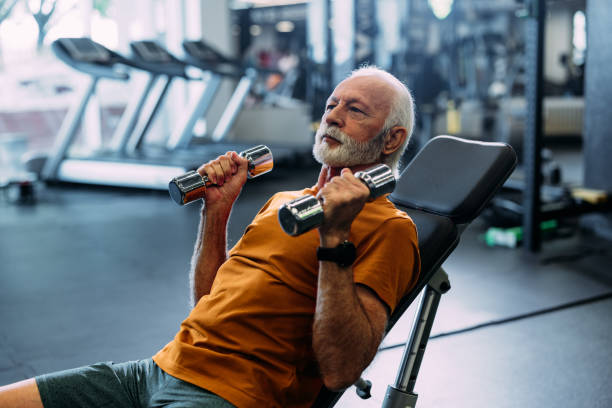 istock Senior Man Lifting Dumbbells at the Gym for Strength Training 2155615558