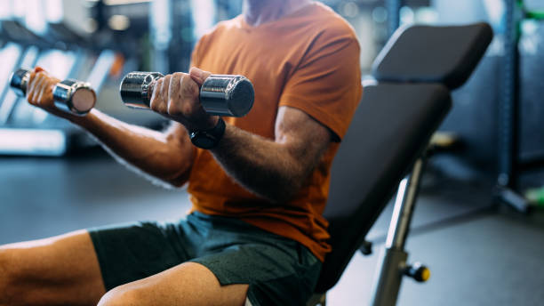 istock Senior Man Exercising with Dumbbells in Modern Gym Setting 2155616067