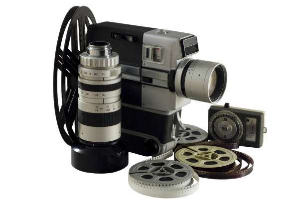 Old camera, lens, light meter and movie reels isolated on white
