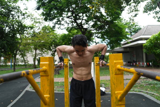 istock Asian man practicing gymnastics doing gymnastics bar and hoop exercises and stretching and resting for sports. 2155621875