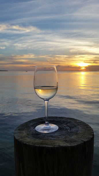 istock Wine glass on dock post at sunset in Islamorada, Florida at sunset. 2155624495