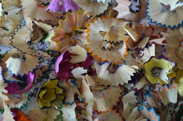 A vibrant close-up image of colorful pencil shavings left over from the sharpening process. The multi-colored fragments of wood and graphite create a visually appealing scene that highlights creativity and artistic expression. Perfect for illustrating themes related to art, education, and the creative process.
