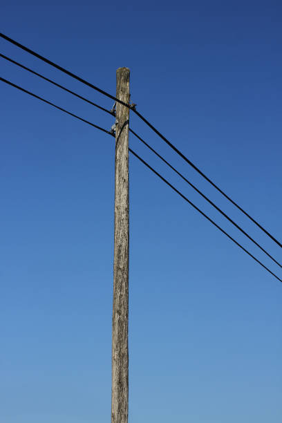 istock A powerline on a wooden pole with blue sky in the background 2155626147