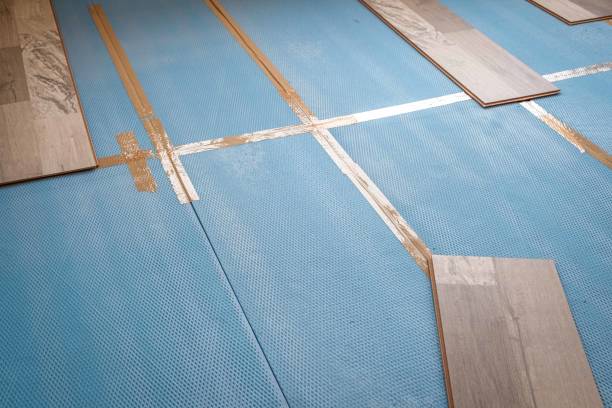 istock Installing laminate flooring in a room or office. Wooden parquet boards background and tools. Construction and decorative works for the finishing of housing 2155629004