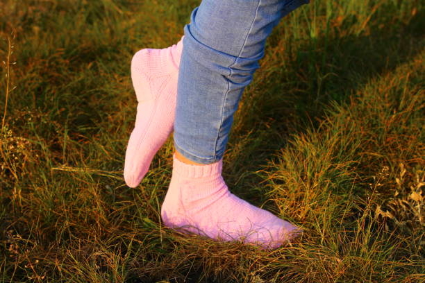 istock A person's legs in a grass field 2155634409