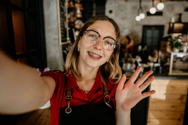 istock Happy young female barista making selfie in a cafe 2155641439