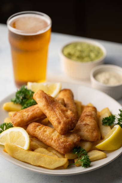 istock fish and chips with ale beer, tartar and mushy peas 2155641912