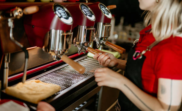 istock happy young female barista making coffee with a coffee machine in a cafe. 2155644468