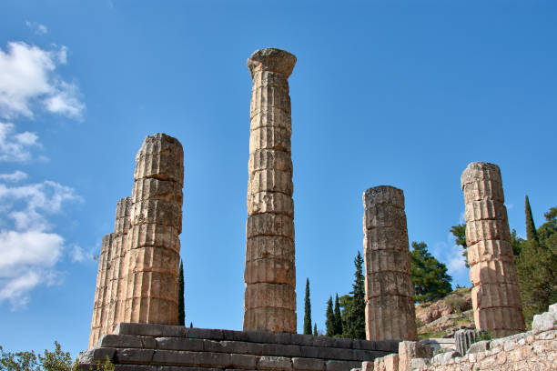 View of the ancient theater in Delphi, Greece, with stone tiers stark against the lush valley and encasing mountains.