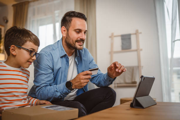 istock Father hold credit card buy online on tablet while son hold package 2155647984