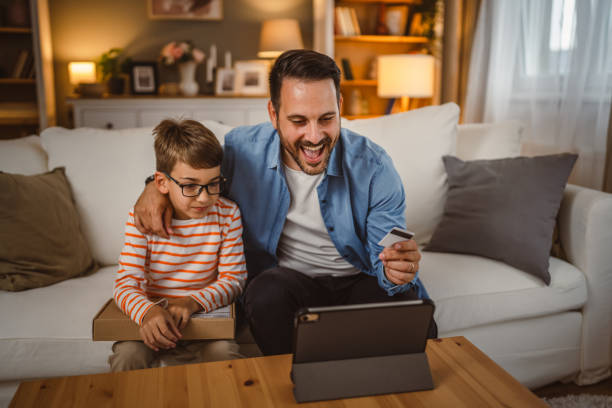 istock Father hold credit card buy online on tablet while son hold package 2155648033