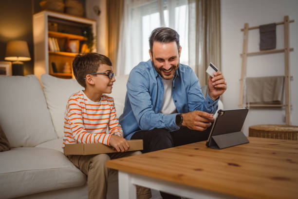 istock Father hold credit card buy online on tablet while son hold package 2155648658