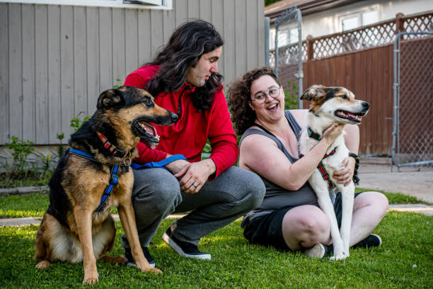 istock nonbinary Person Sitting on Lawn with Rescue Dog Outdoors 2155652222
