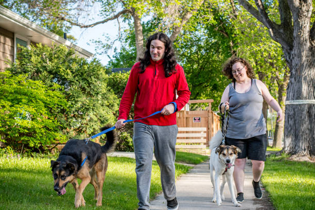 istock training Dogs walking on Sidewalk: Nonbinary Person and hispanic partner 2155652251