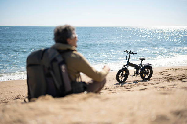 istock E-bike Sea Tour. Man on the Beach in Spring. 2155652986