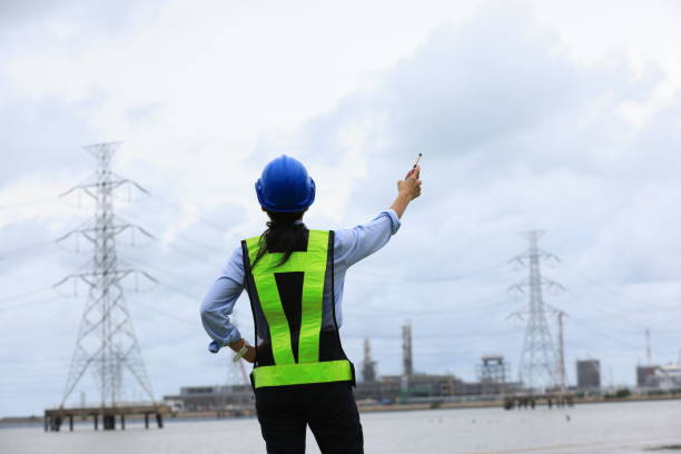 istock Asian woman Senior engineer hold drawing working at site line,  Site electrical project engineer working for new power plant 2155660211