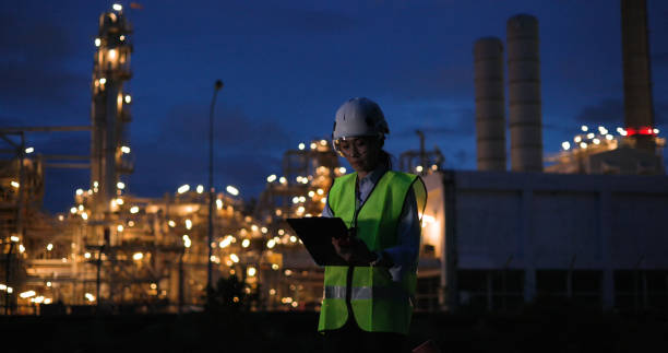 istock Senior female industrial engineer excelling with a digital tablet during the night shift at a chemical industrial site. 2155660399