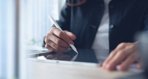 istock Businesswoman using stylus pen signing on digital tablet via mobile app, proofing e-document on office table. Business woman, project manager planning and working on computer, business technology 2155664934