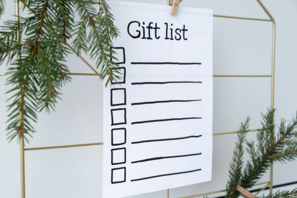 istock Preparation for winter holidays. GIFT LIST text on paper note. Celebration gifts and presents preparing Natural zero waste homemade Christmas decor. Happy new year 2155668491