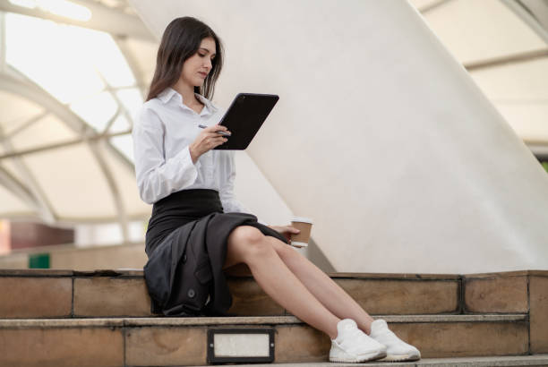 istock Businesswoman sitting on stair working online outside workplace using wireless technology connection 2155669169