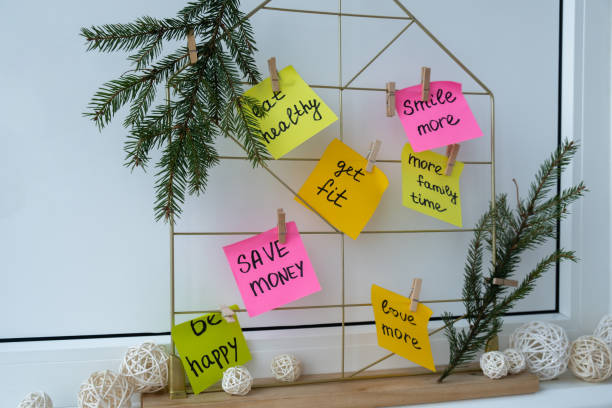 istock Action board new year's resolutions on colorful sticky notes. Making promises for new year, setting goals. Dream year 2155669320