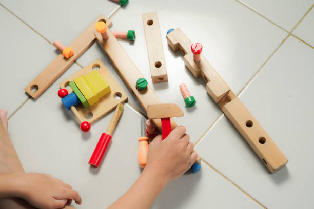istock children hands playing with colorful wooden constructor puzzle bricks 2155673299