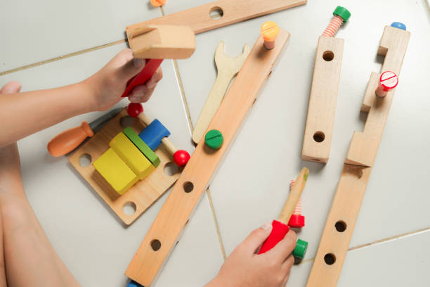 istock children hands playing with colorful wooden constructor puzzle bricks 2155673426