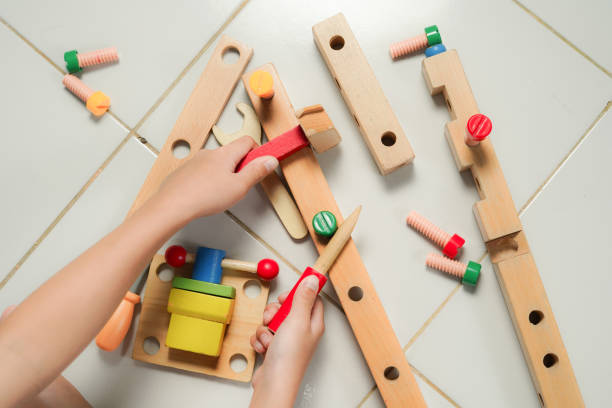 istock children hands playing with colorful wooden constructor puzzle bricks 2155673430