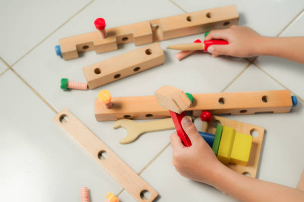 istock children hands playing with colorful wooden constructor puzzle bricks 2155673446