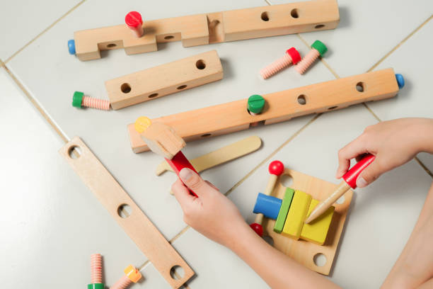 istock children hands playing with colorful wooden constructor puzzle bricks 2155673468