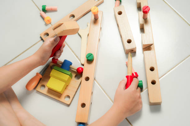 istock children hands playing with colorful wooden constructor puzzle bricks 2155674034