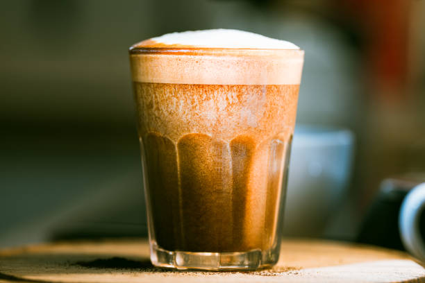 Glass of Natural cereal coffee with oat milk. Blurry dark restaurant background.