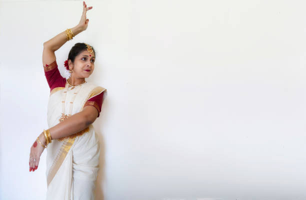 Indian woman in traditional clothes offering rose petals to the gods. 