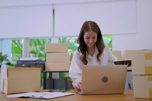 istock Young female entrepreneur is packing merchandise  at home. 2155678149