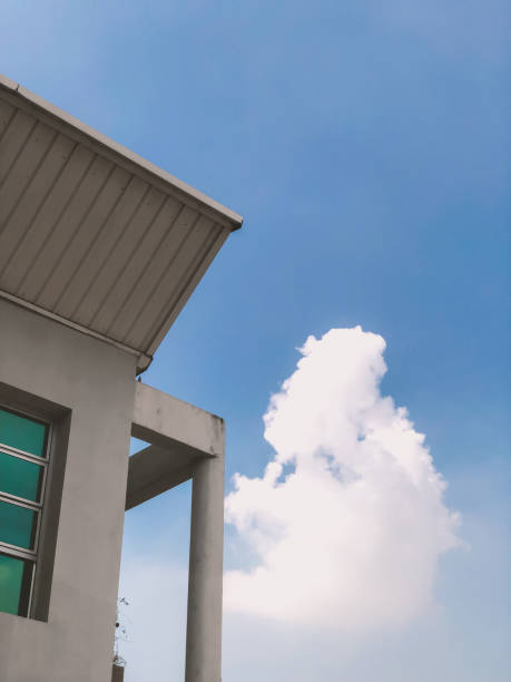 istock A white building with a blue roof and a cloud in the sky 2155678334