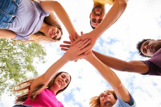 istock Low angle view of multiracial friends stacking hand together at street. 2155681113
