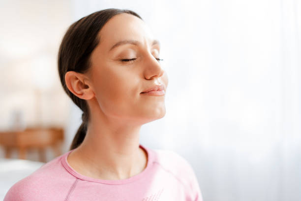 istock Beautiful women with closed eyes breathing while relaxing after exercising workout 2155681553