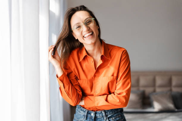 istock Smiling woman in eyeglasses looking at camera while posing at home 2155681623