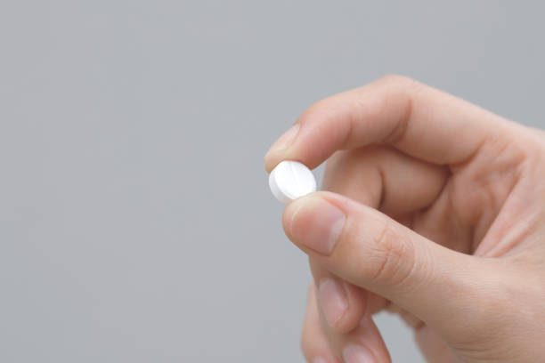istock close up hand man taking multiple pills take a medicine in hand holding a cup glass of drinking water on wooden table. Stop drug use Taking Medication health care medical concept. 2155681916
